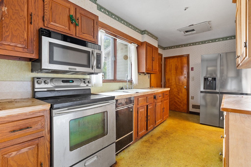 94 Gordon Road Braintree, MA 02184 - Photo 13 of 25 a kitchen with a stove top oven sink and cabinets