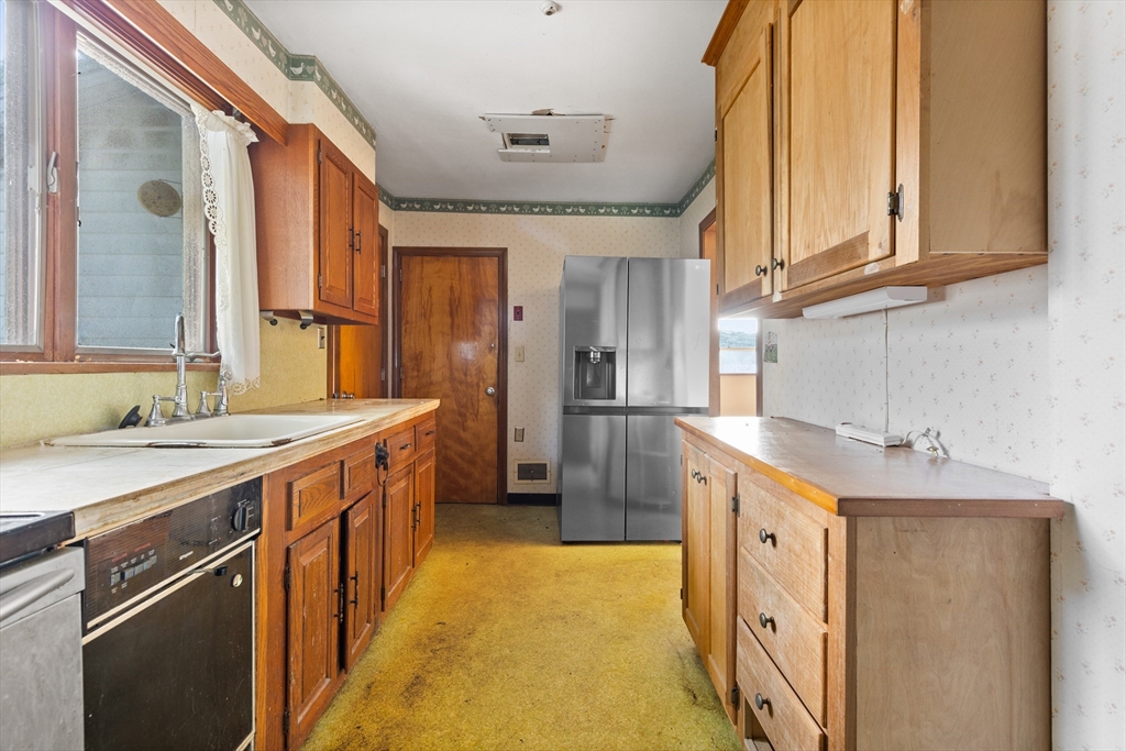 94 Gordon Road Braintree, MA 02184 - Photo 14 of 25 a kitchen with stainless steel appliances granite countertop a sink and dishwasher a oven with white cabinets