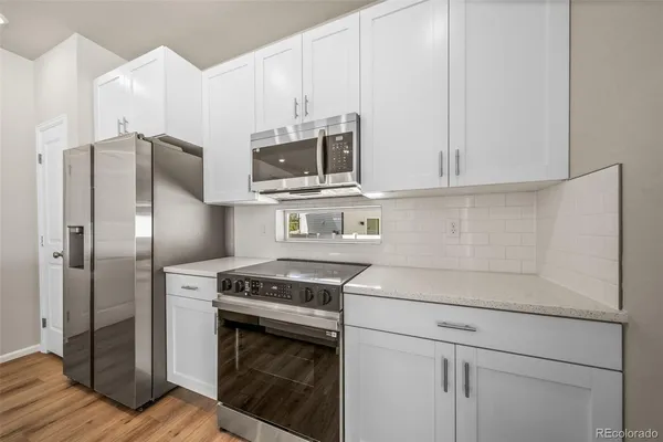 a kitchen with stainless steel appliances white cabinets and a stove