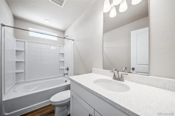 a bathroom with a sink a toilet and a large mirror
