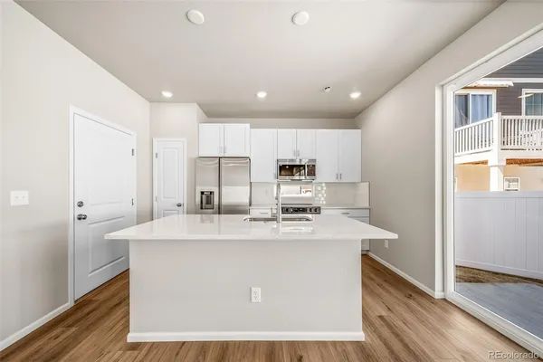 a kitchen with stainless steel appliances granite countertop a sink a refrigerator and a stove