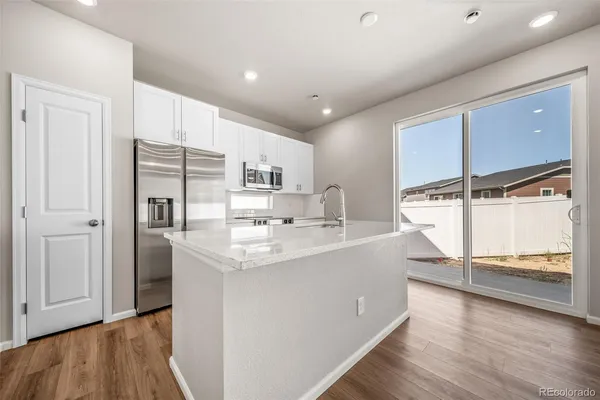 a kitchen with stainless steel appliances a sink and refrigerator