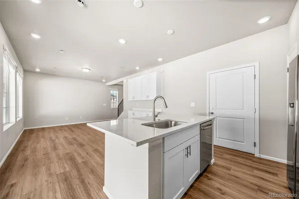 a kitchen with a sink and wooden floor