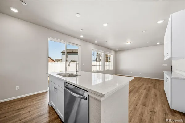 a kitchen with stainless steel appliances granite countertop a sink and a wooden floors