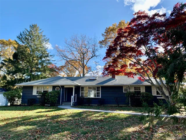 a front view of a house with yard and green space