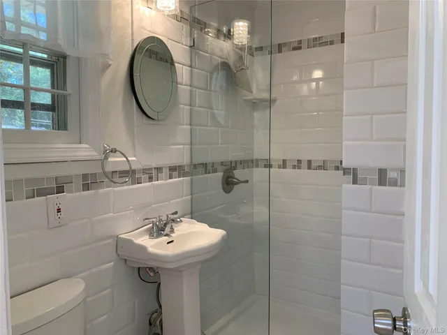 a bathroom with a sink a toilet and a mirror