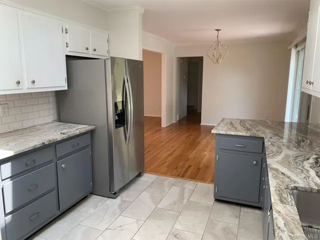 a kitchen with stainless steel appliances granite countertop a refrigerator and a stove