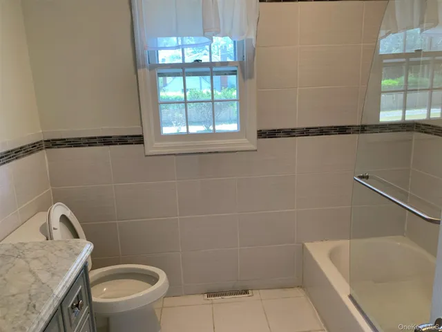 a bathroom with a granite countertop bathtub and a toilet