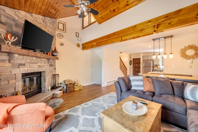 a outdoor living space with furniture a flat screen tv and a fireplace