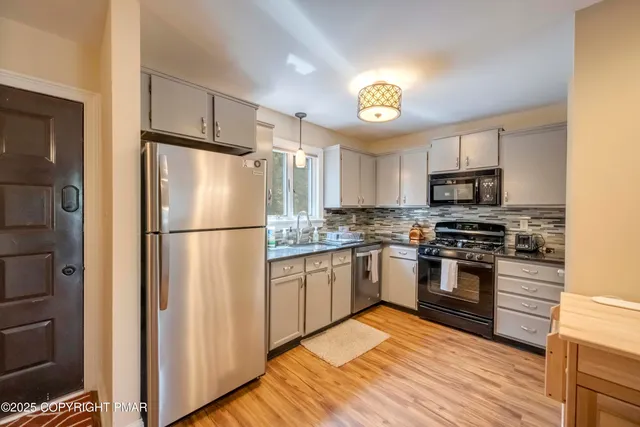a kitchen with granite countertop a refrigerator stove and oven