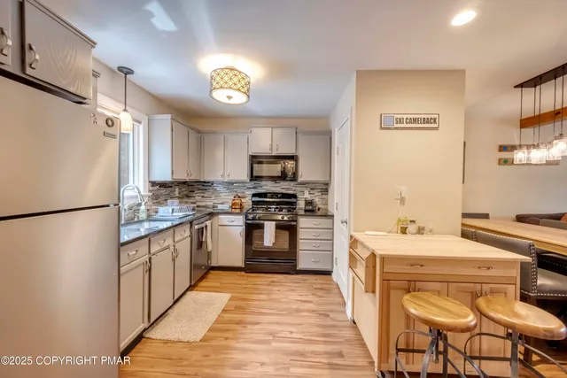a kitchen with stainless steel appliances a refrigerator stove microwave and sink