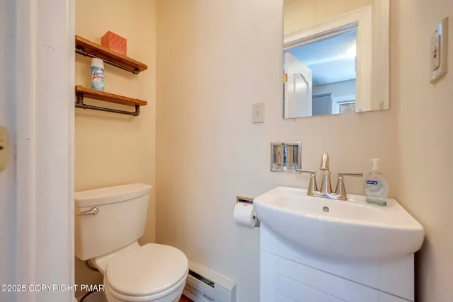 a bathroom with a toilet sink and mirror