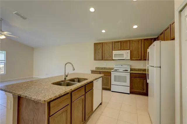 a kitchen with granite countertop a sink cabinets and window