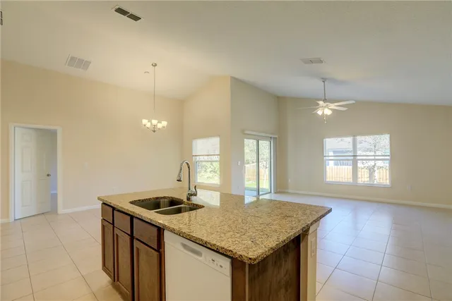 a kitchen with granite countertop a refrigerator sink and stove