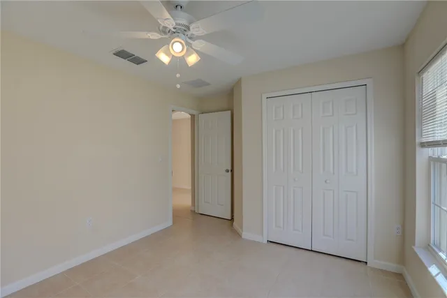an empty room with a window and a fan