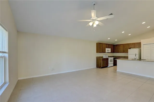 a large kitchen with a large counter top a sink stainless steel appliances and cabinets