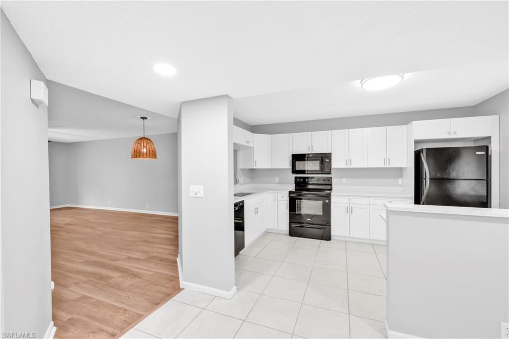 7791 Esmeralda Way, Unit L103 Naples, FL 34109 - Photo 22 of 22 a kitchen with stainless steel appliances a refrigerator and a stove top oven