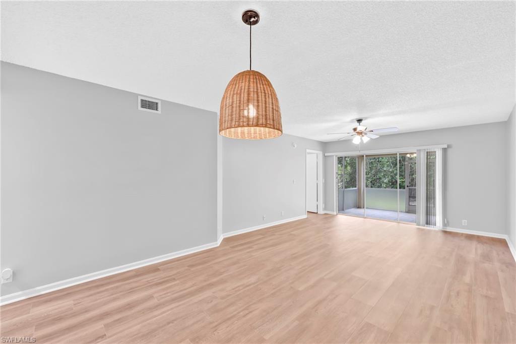 7791 Esmeralda Way, Unit L103 Naples, FL 34109 - Photo 13 of 22 a view of an empty room with window and chandelier fan