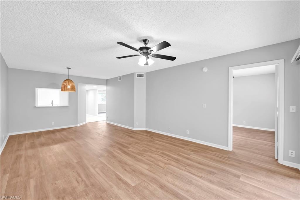 7791 Esmeralda Way, Unit L103 Naples, FL 34109 - Photo 14 of 22 wooden floor in an empty room with a window