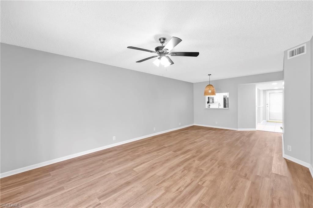 7791 Esmeralda Way, Unit L103 Naples, FL 34109 - Photo 15 of 22 wooden floor in an empty room with a window
