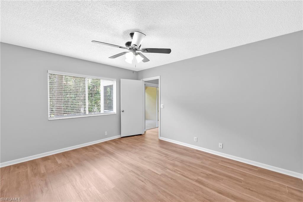 7791 Esmeralda Way, Unit L103 Naples, FL 34109 - Photo 19 of 22 a view of an empty room with wooden floor and a window