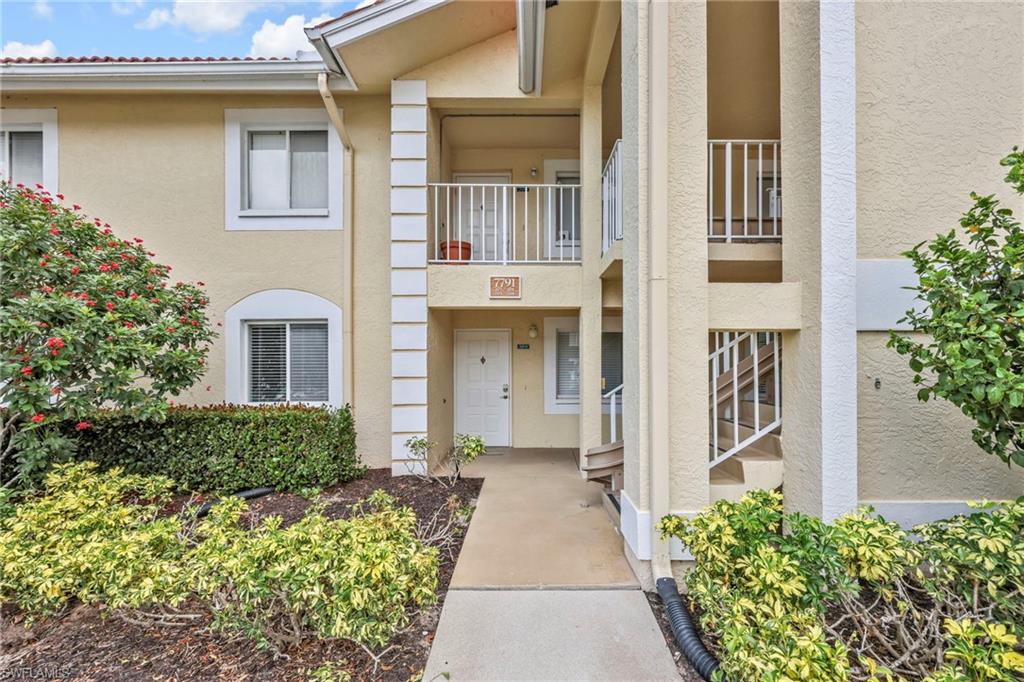7791 Esmeralda Way, Unit L103 Naples, FL 34109 - Photo 2 of 22 front view of a house with a small yard