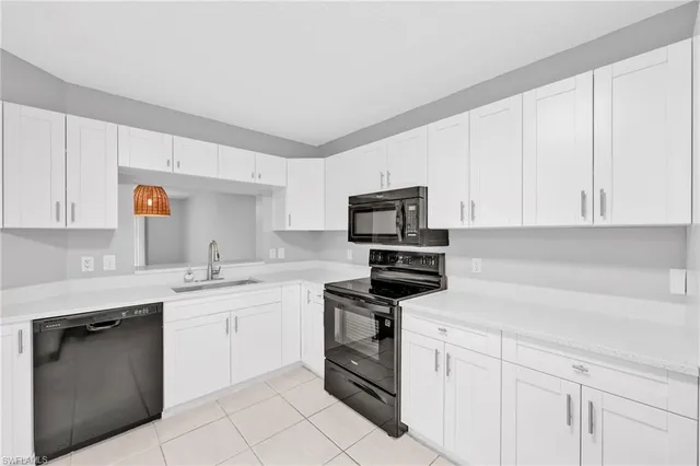 a kitchen with white cabinets stainless steel appliances and sink