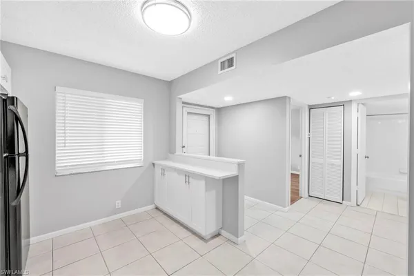 a view of an empty room with window and cabinet
