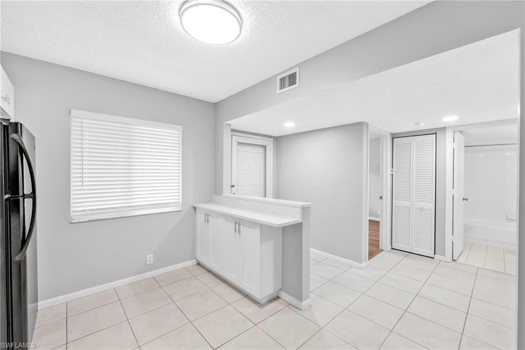 7791 Esmeralda Way, Unit L103 Naples, FL 34109 - Photo 7 of 22 a view of an empty room with window and cabinet