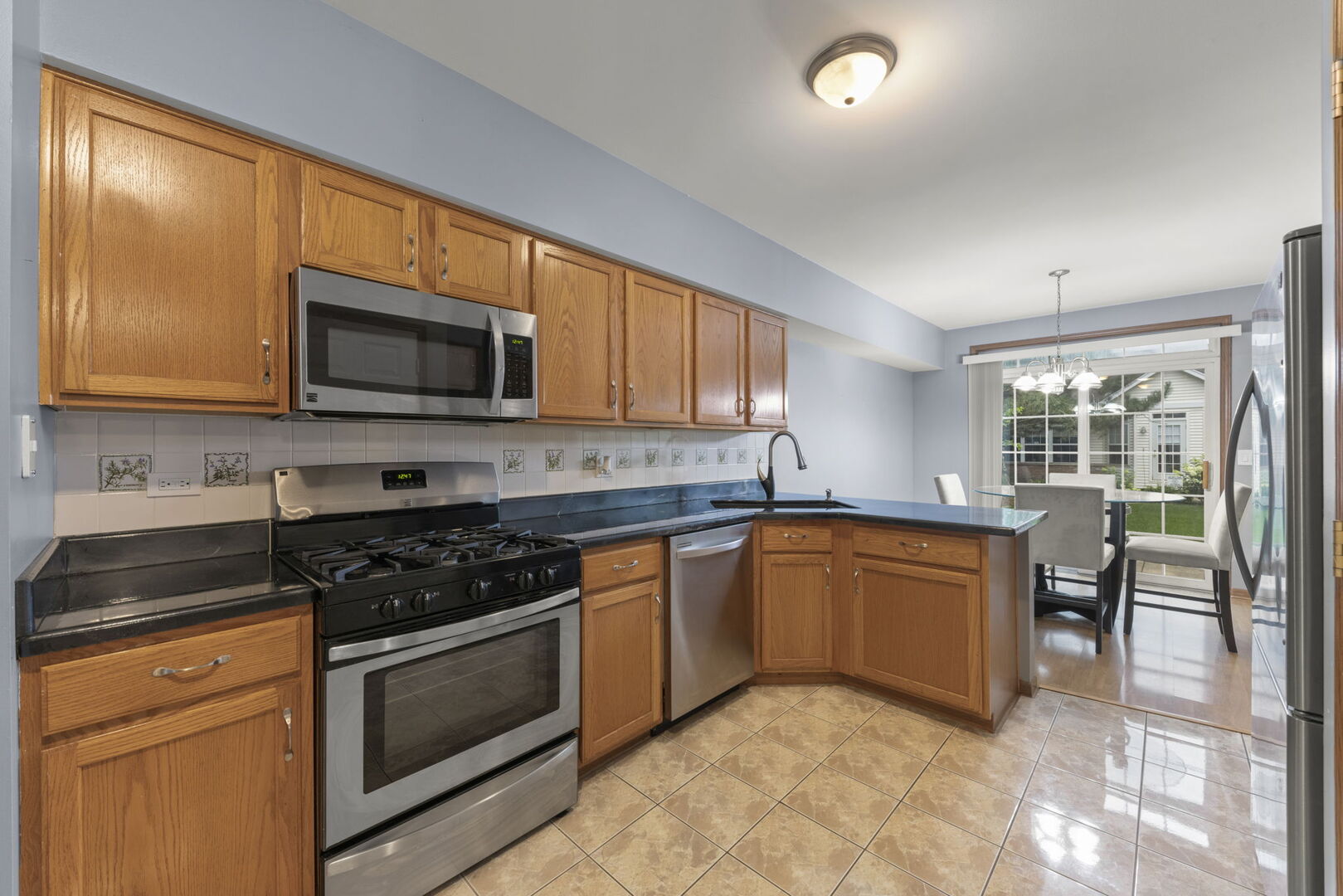 16727 South Sunset Ridge Court Lockport, IL 60441 - Photo 10 of 30 a kitchen with granite countertop a stove top oven microwave and cabinets