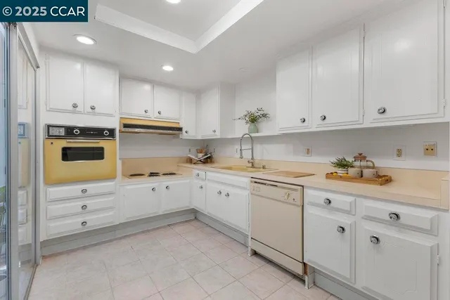 a kitchen with granite countertop white cabinets and white appliances