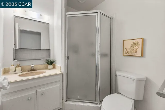 a bathroom with a toilet sink vanity and mirror