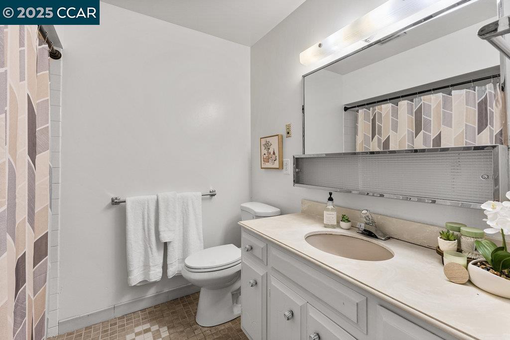 1833 Skycrest Drive, Unit 2 Walnut Creek, CA 94595 - Photo 21 of 28 a bathroom with a granite countertop sink and a toilet