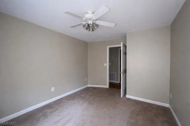an empty room with closet and a chandelier fan