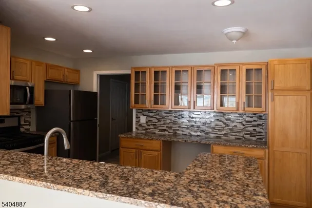 a kitchen with stainless steel appliances granite countertop a refrigerator and a sink