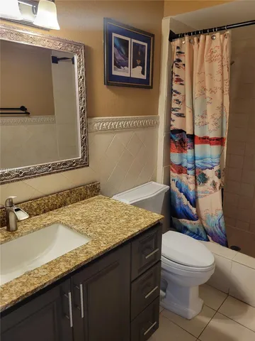 a bathroom with a granite countertop sink mirror vanity and toilet