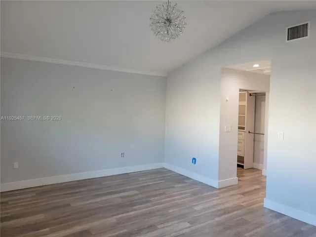 a view of a room with wooden floor and white walls