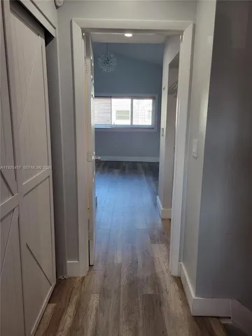 a view of hallway with wooden floor and window