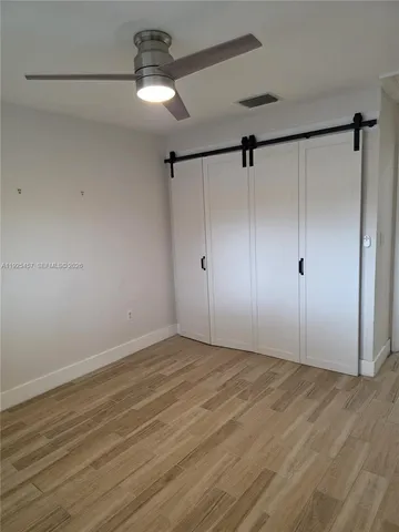 a view of a room with an empty space and a ceiling fan
