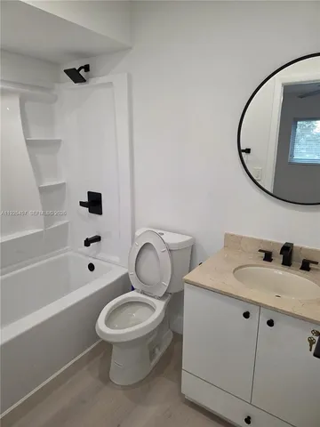 a white toilet sitting next to a bathroom sink and a mirror