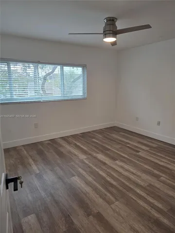 wooden floor in an empty room with a window