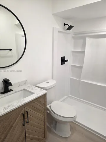 a bathroom with a sink a toilet and a mirror
