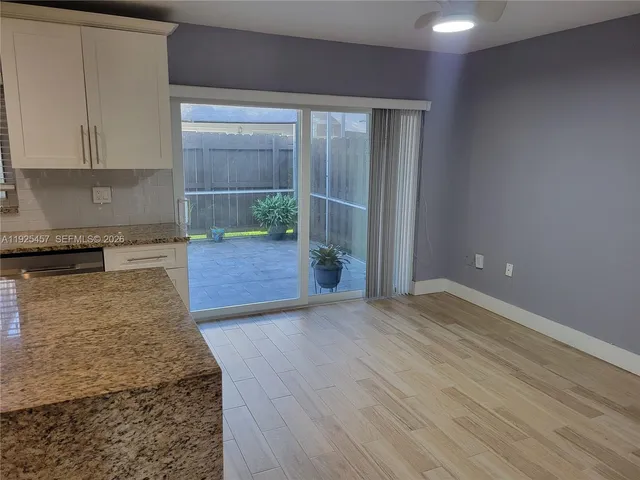 a view of a kitchen with wooden floor and a sink