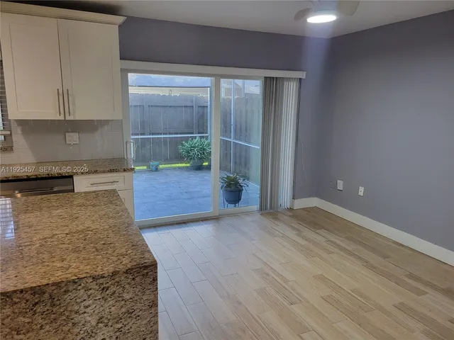 a view of a kitchen with wooden floor and a sink