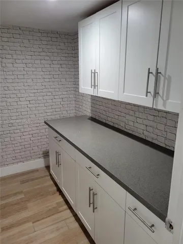 a kitchen with a sink and a wooden floor