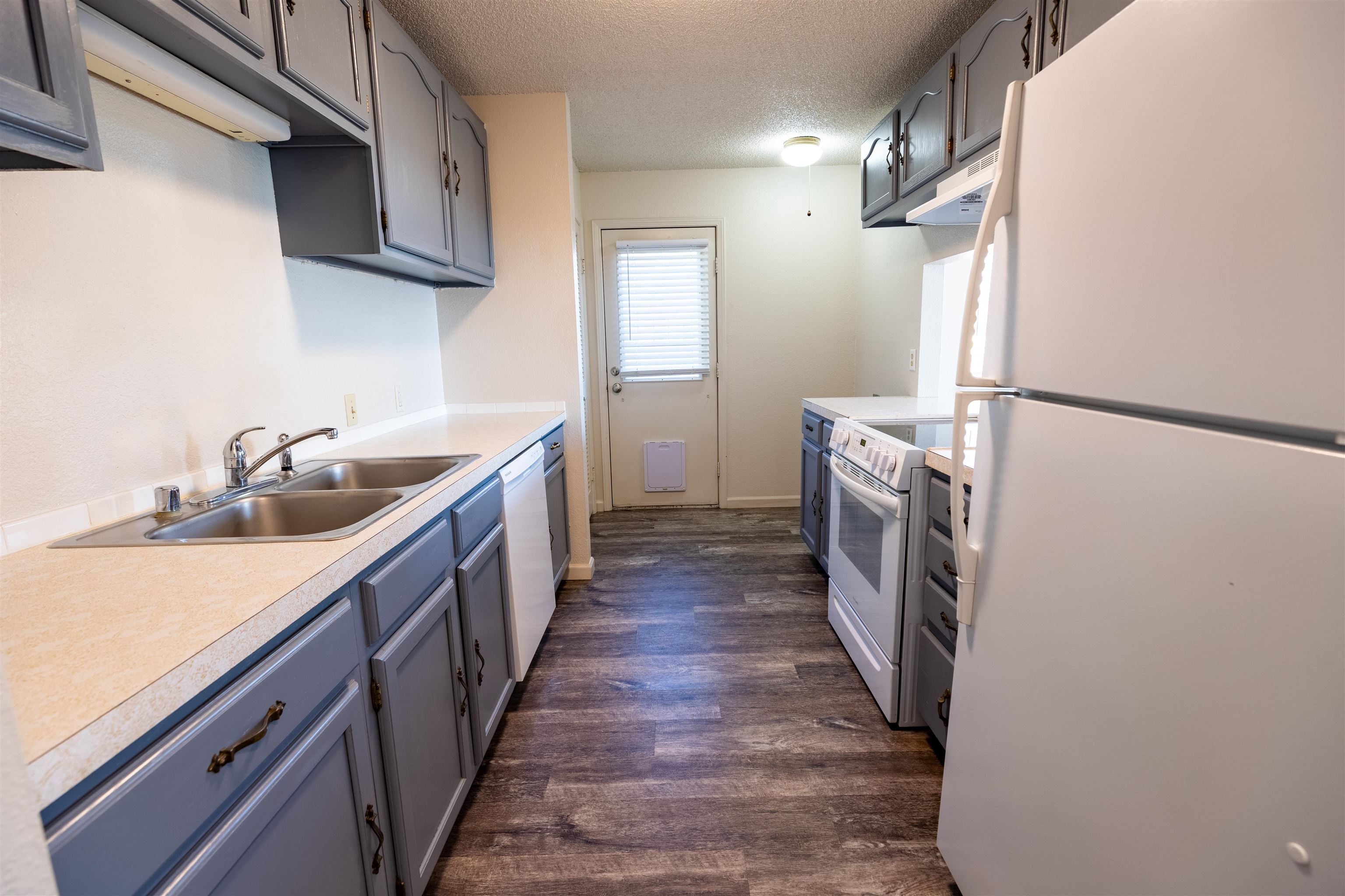 239 South Elm Street, Unit A Fruita, CO 81521 - Photo 6 of 22 a kitchen with sink a refrigerator and wooden cabinets