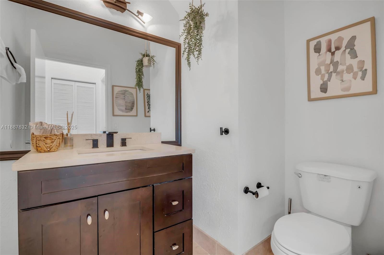 14836 Southwest 51st Street Davie, FL 33331 - Photo 14 of 34 a bathroom with a toilet sink and mirror