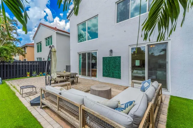 a view of a patio with couches table and chairs and potted plants