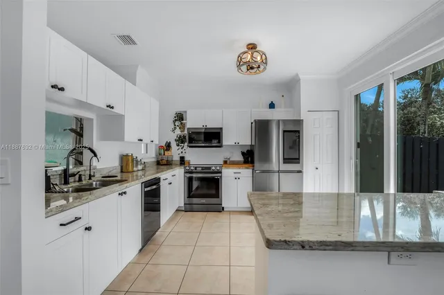 a kitchen with stainless steel appliances granite countertop a sink dishwasher stove top oven and cabinets