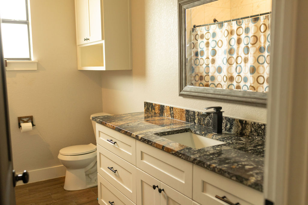 111 Powder Ridge Luling, TX 78648 - Photo 8 of 22 A well-appointed bathroom with richly veined stone counters and sleek cabinetry offers refined comfort.